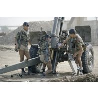 Des soldats du 11e RAMa arment un canon de 105 mm en batterie.