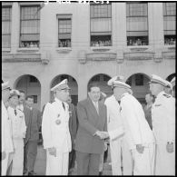 Jacques Soustelle serre la main d'un officier pendant la cérémonie à la stèle aux marins à Alger.