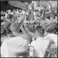 Les rappelés sont acclamés par la foule au débarquement dans le port d'Alger.