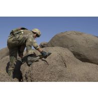 Un sapeur du 6e régiment du génie (6e RG) saisit un obus découvert dans une cache de munitions dans la région de Tessalit, au Mali.