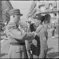 Le général Raoul Salan décore un brigadier-chef du 411ème régiment d'artillerie (RA) de la médaille militaire.