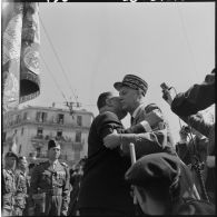 A l'issue du défilé, et avant de se rendre au monument aux morts, le général d'armée Raoul Salan, remet à Robert Lacoste, la croix de la valeur militaire avec palme.