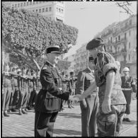 Le général de brigade Massu remet à un commandant la croix de chevalier de la légion d'honneur.