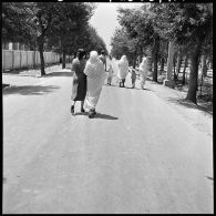 Algérie. Une famille marche sur une route.