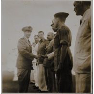 Avant de prendre l'avion pour la France, l'amiral Thierry d'Argenlieu fait ses adieux et serre la main aux officiers et personnalités civiles venus le saluer.