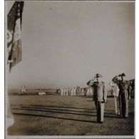 Haut-commissaire de France en Indochine, Georges Thierry d'Argenlieu salue le drapeau d'un bataillon de la Légion étrangère en compagnie d'autres personnalités.
