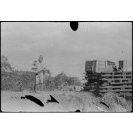 [Opération Gaur en Indochine, janvier-mars 1946. Garde japonais sur la route de Djiring à côté de matériel pour la construction de passerelles.]