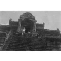 [Angkor Vat, 10 septembre 1946. Visite du général Zinovi Pechkoff à Angkor et descente périlleuse des marches du temple.]
