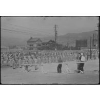 [Japon, juin 1946. Des soldats néo-zélandais accueillant leur général à la gare de Kure.]