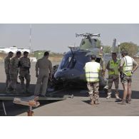 Chargement d'un hélicoptère Agusta A.109 belge à bord d'un avion de transport Super Hercules C-130 à Bamako, au Mali.