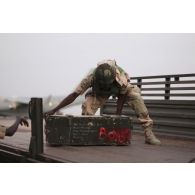 Un soldat nigérian charge des caisses de matériel à bord d'un camion sur l'aéroport de Bamako, au Mali.