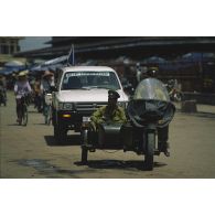 Patrouille conjointe de la police cambodgienne en side-car avec un véhicule pick-up 4x4 de patrouille de la Police civile (CivPol) de l'APRONUC à Battambang.