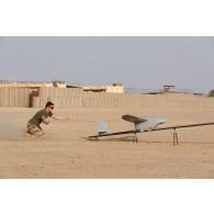 Un artilleur du 93e régiment d'artillerie de montagne (RAM) déclenche le dispositif de catapultage d'un système de mini drone de reconnaissance (SMDR) avant son lancement sur la base de Tessalit, au Mali.