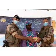 Un aumônier musulman accompagné du chef d'une équipe de coopération civilo-militaire (CIMIC) remet des denrées alimentaires à la présidente de institut des jeunes aveugles (IJA) de Gao, au Mali.