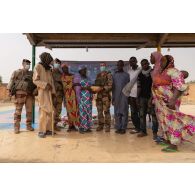 Un aumônier musulman accompagné du chef d'une équipe de coopération civilo-militaire (CIMIC) remet des denrées alimentaires à l'institut des jeunes aveugles (IJA) de Gao, au Mali.