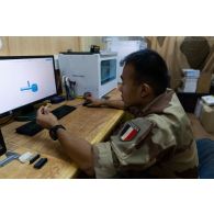 Le sergent Julien conçoit une pièce à imprimer sur l'interface graphique d'une imprimante dans son bureau à Gao, au Mali.