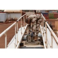 Le brigadier-chef Jean-Maurice, technicien des tests de carburant, ouvre les cuves d'un camion-citerne sur la base de Gao, au Mali.