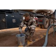 Le brigadier-chef Jean-Maurice, technicien des tests de carburant, analyse la contenance d'eau dans l'essence d'un camion-citerne sur la base de Gao, au Mali.