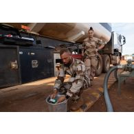 Le brigadier-chef Jean-Maurice, technicien des tests de carburant, contrôle l'électricité dans l'essence d'un camion-citerne au moyen d'un multimètre sur la base de Gao, au Mali.
