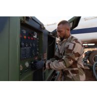 Le brigadier-chef Jean-Maurice, technicien des tests de carburant, configure une motopompe pour transférer l'essence d'un camion-citerne vers un bac souple sur la base de Gao, au Mali.