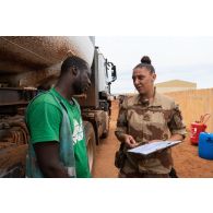 Le maréchal des logis Anaïs, adjointe au chef de détachement du Service de l'énergie opérationnelle (SEO), signe le document de contenance de carburant d'un camion-citerne sur la base de Gao, au Mali.
