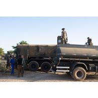 Recomplètement d'un camion-citerne polyvalent Scania CCP10 par un camion-citerne burkinabè à Kaya, au Burkina Faso.