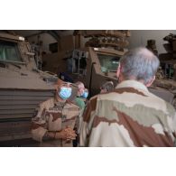 Un sous-officier du 8e régiment du matériel (RMAT) présente les ateliers de maintenance du véhicule blindé multi-rôles (VBMR) Griffon au délégué général pour l'armement Joël Barre à Gao, au Mali.