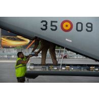 Un soldat de l'escale aide un personnel navigant espagnol à embarquer du matériel à bord d'un avion Casa Cn-235 à Libreville, au Gabon.