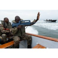 Des soldats congolais sécurisent une plage de la Pointe Denis à bord d'une barque au centre d'aguerrissement Outre-Mer et étranger (CAOME) de Libreville, au Gabon.