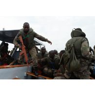 Des soldats congolais embarquent dans une barque à la Pointe Denis au centre d'aguerrissement Outre-Mer et étranger (CAOME) de Libreville, au Gabon.