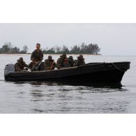 Des soldats congolais accompagnés d'un instructeur du 6e bataillon d'infanterie de marine (BIMa) naviguent à bord d'une barque vers la Point Denis au centre d'aguerrissement Outre-Mer et étranger (CAOME) de Libreville, au Gabon.
