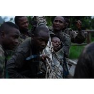Des soldats congolais évacuent leur camarade blessé pour un exercice en forêt à Libreville, au Gabon.