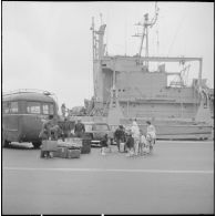 Femmes et enfants partant du port d'Oran pour la France, aidés par des soldats.