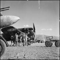Des armuriers chargent une bombe de 500 livres sur un avion de chasse Bearcat avant son départ en mission sur le terrain de Diên Biên phu.