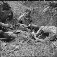 Le médecin-lieutenant Patrice Le Nepvou de Carfort  du 8e bataillon de parachutistes de choc (BPC) apporte les premiers secours à un parachutiste autochtone blessé au cours d'une reconnaissance au nord de Diên Biên Phu.