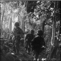 Au cours d'une reconnaissance au nord de Diên Biên Phu, ces parachutistes du 8e bataillon de parachutistes de choc (BPC) font une halte dans la forêt tandis que d'autres continuent leur progression.