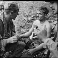 L'infirmier du 8e bataillon de parachutistes de choc (BPC) apporte les premiers soins au sergent Francheschi, blessé au cours d'un accrochage lors d'une reconnaissance au nord de Diên Biên Phu.