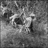 Au cours d'une reconnaissance au nord de Diên Biên Phu, des parachutistes du 8e bataillon de parachutistes de choc (BPC) transportent un soldat vietminh blessé vers l'arrière pour le faire soigner.