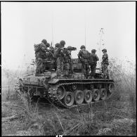 Un char M24 Chaffee de l'escadron de marche du 1er régiment de chasseurs à cheval (RCC) transportant des fantassins au cours d'une offensive contre des positions de l'Armée populaire vietnamienne à Diên Biên Phu.