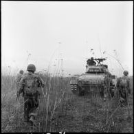 Patrouille de l'infanterie avec l'appui de blindés du 3e régiment de marche du 1er régiment de chasseurs à cheval (RCC) au cours d'une offensive contre des positions de l'Armée populaire vietnamienne à Diên Biên Phu.