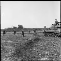 Assaut de fantassins appuyés par des chars M24 Chaffee du 3e escadron de marche du 1er régiment de chasseurs à cheval (RCC) au cours d'une offensive contre des positions de l'Armée populaire vietnamienne à Diên Biên Phu.