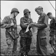 Briefing entre le capitaine Hervouët, commandant le 3e escadron de marche du 1er Régiment de chasseurs à cheval (1er RCC), et des fantassins au cours d'une offensive contre des positions de l'Armée populaire vietnamienne à Diên Biên Phu.