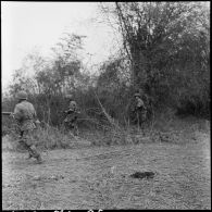 Fantassins progressant au cours d'une offensive menée avec l'appui de blindés contre des positions de l'Armée populaire vietnamienne à Diên Biên Phu.
