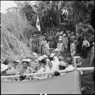 Accompagnés par des soldats de l'Armée populaire vietnamienne du camp de transit, les derniers prisonniers de l'Union française libérés embarquent à bord du LCM.