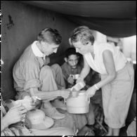 Mme Pidot, assistante sociale, distribue de l'eau aux soldats de l'Union française libérés à Viet Tri à bord d'un bâtiment de débarquement qui les rapatrie vers Hanoï.