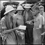 Des légionnaires libérés par l'Armée populaire vietnamienne échangent au cours de leur rapatriement vers Hanoï à bord d'un bâtiment de débarquement.