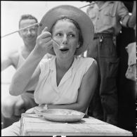 Portrait de Mme Pidot, assistante sociale, en train de manger à bord d'un LCM qui rapatrie des prisonniers de guerre libérés par l'Armée populaire vietnamienne vers Hanoï.