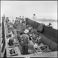 Prisonniers de guerre de l'Union française libérés par l'Armée populaire vietnamienne installés dans la cuve d'un bâtiment de débarquement au cours de leur rapatriement vers Hanoï.