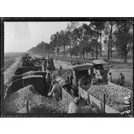 Route d'Amiens à Saint-Quentin. Des pierres pour la réfection des routes sont amenées par train et chargées sur auto camions. [légende d'origine]