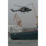 Vol stationnaire d'un hélicoptère Lynx au-dessus de l'Alcyon dans le port de Brest.